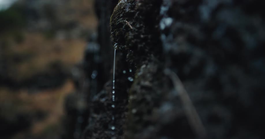 Water dripping in slow motion from lava rock in the canyon