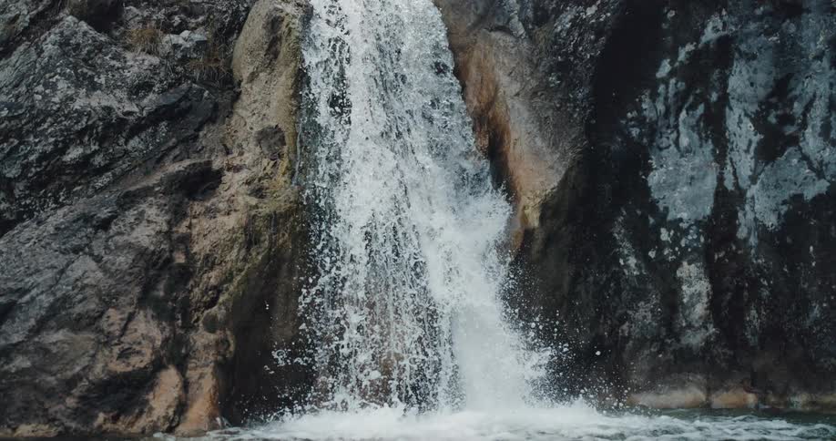 A waterfall crashes down the side of a cliff