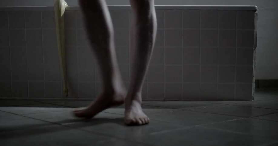 A man steps out of a bathtub that a snake is slithering out of