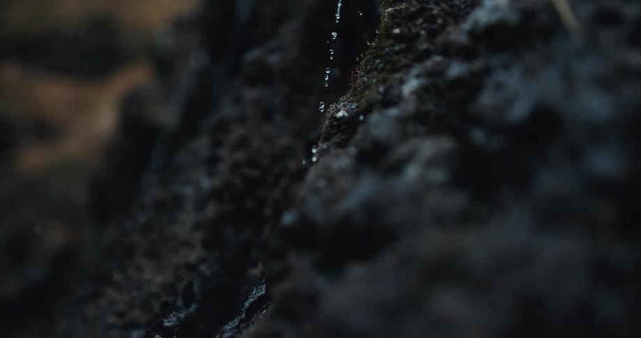 Water dripping down a black rock