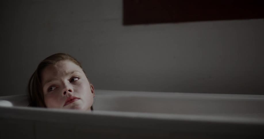 Woman laying on bathtub in a room