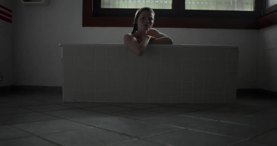 A man walks away from a woman taking a bath