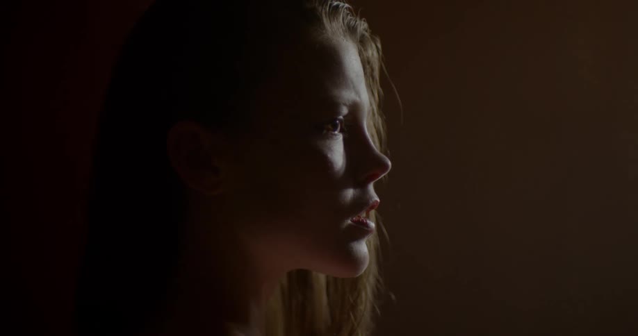 Woman stands in dimly lit room