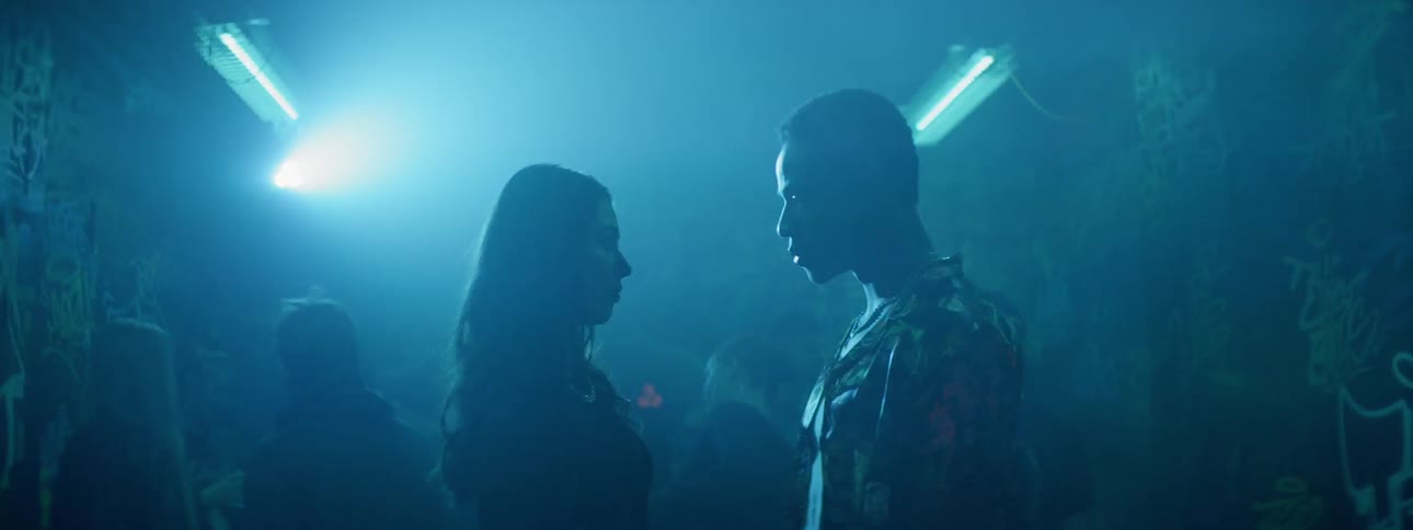 A man and woman staring into each others eyes in a small night club