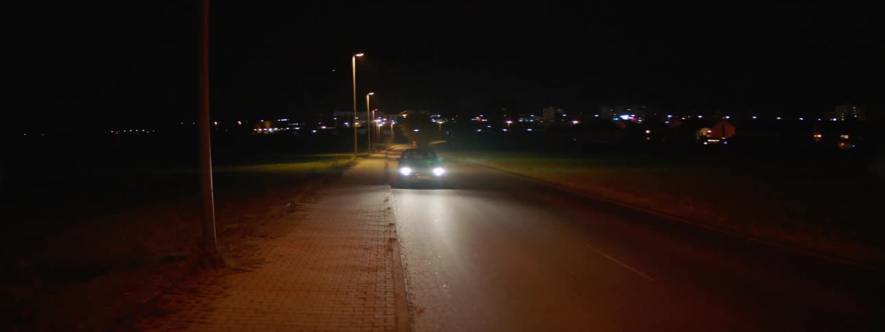 A car pulls to a stop on the side of the road and turns on the hazard lights