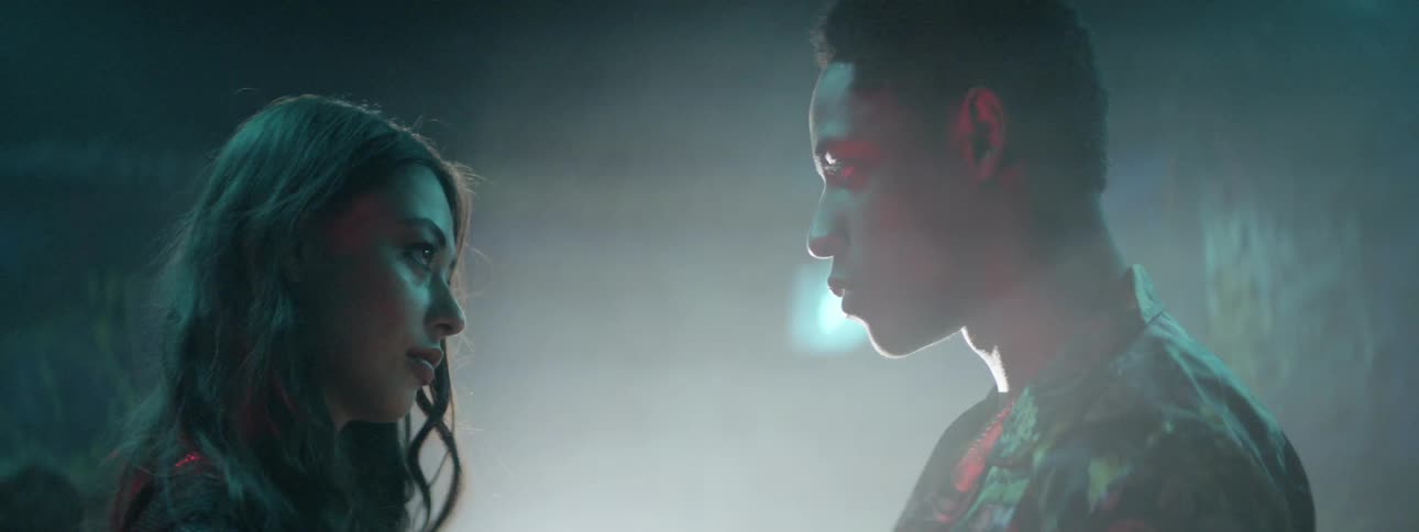 A girl and boy hold hands and look in to one anothers eyes