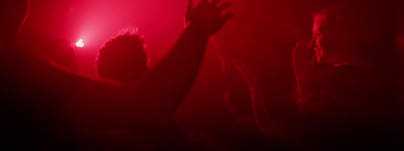 People dancing in a crowded night club under strobing lights