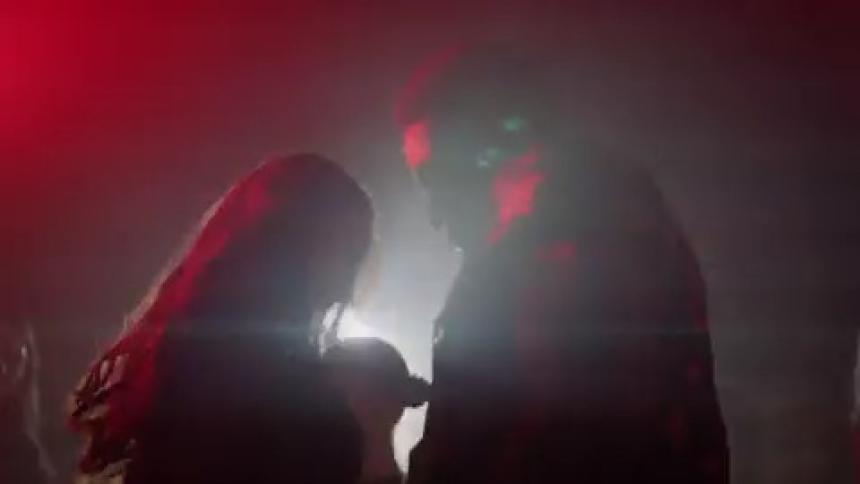 Young people dancing at a discotheque with red and blue lights