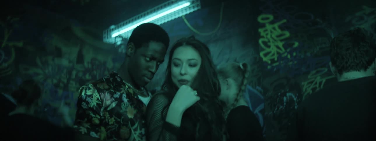 Young people dancing in a room with graffiti covered walls