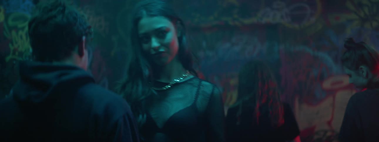 Young people dancing in a room with graffiti covered walls