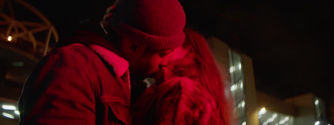 Couple kissing in the middle of the street at night