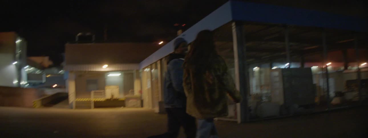 Man and woman run down the city street at night