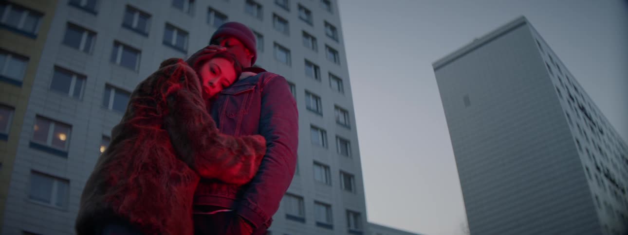 Young couple standing in front of building hugging