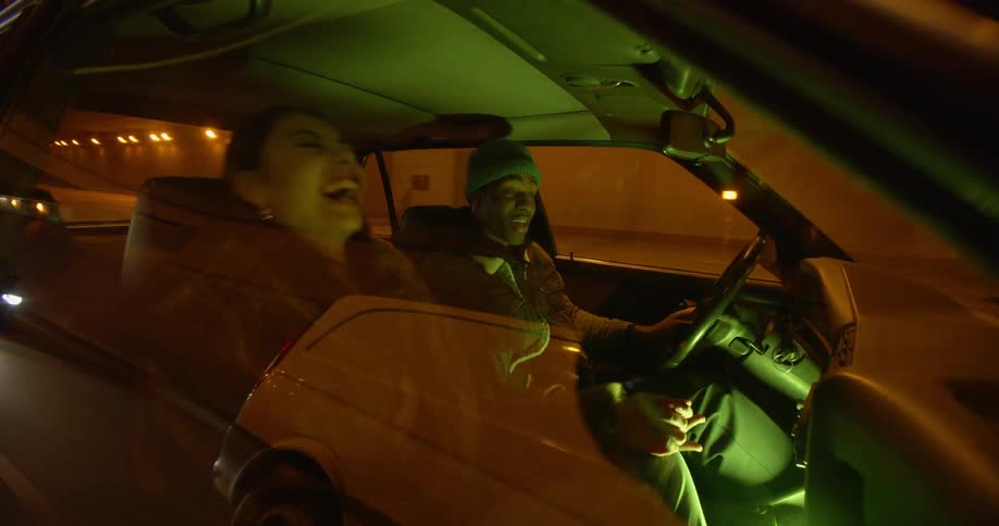 A man and woman talk while driving in a car