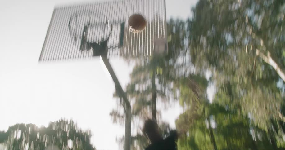 Man shooting hoops at a basketball court in the park