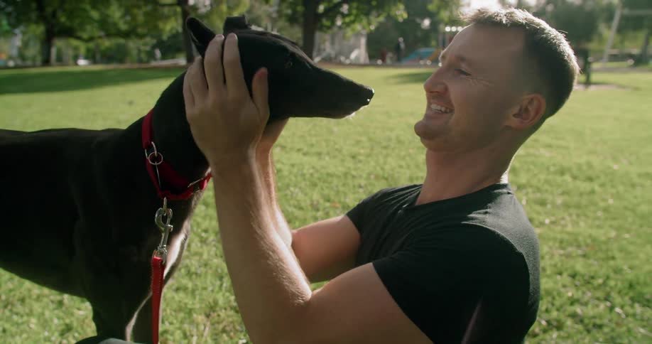 A man pets his dog outdoors