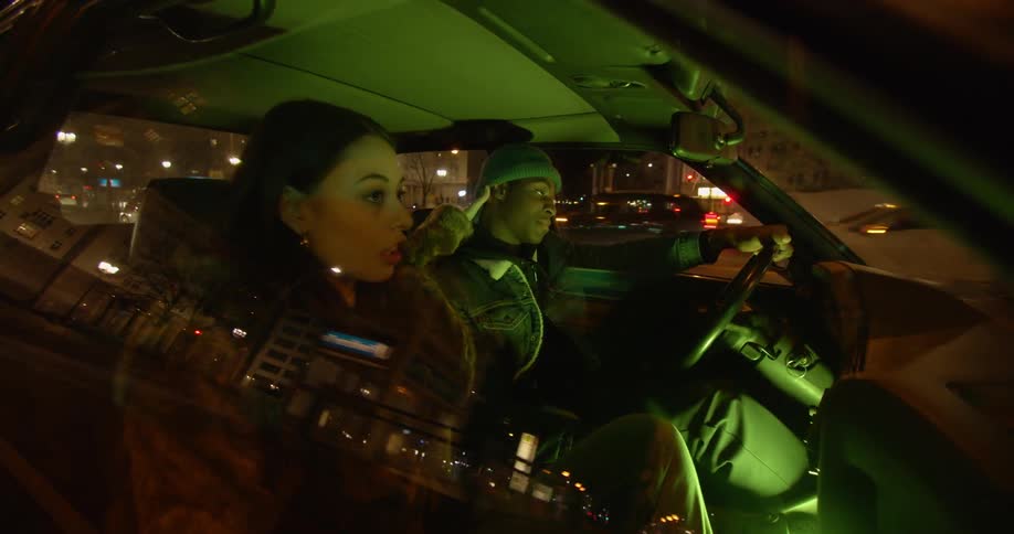 A man and woman talk as they drive in a car