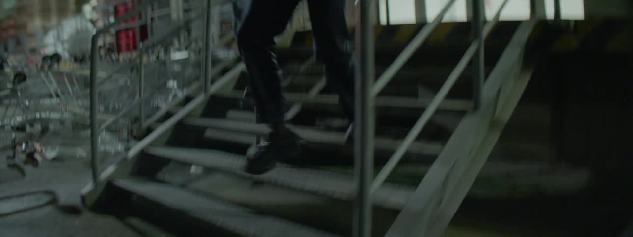 A man and woman run down some stairs hand in hand