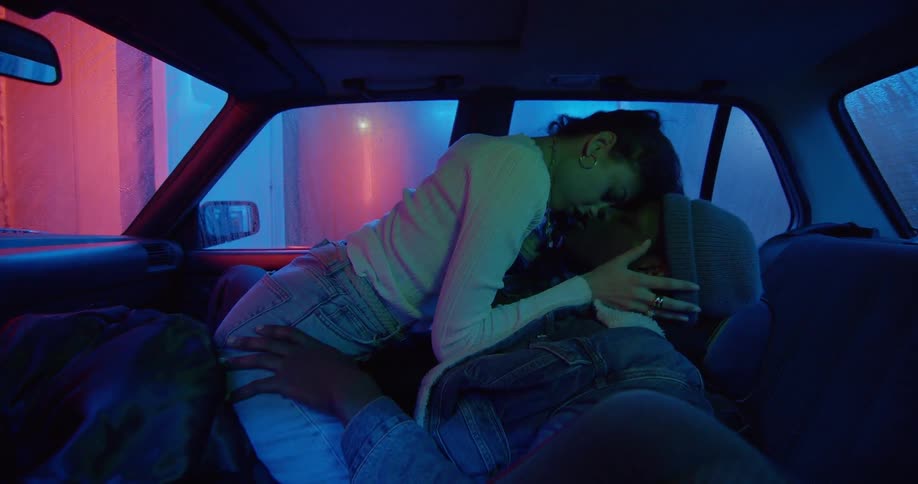 Two teenagers make out in a car