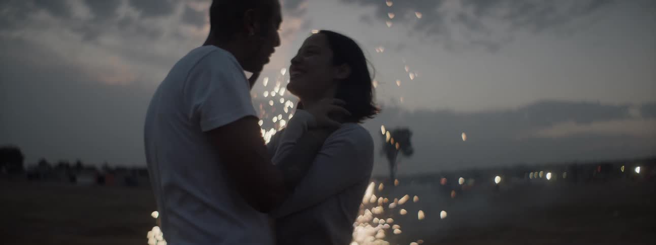 Silhouette of romantic couple while fireworks light up behind them
