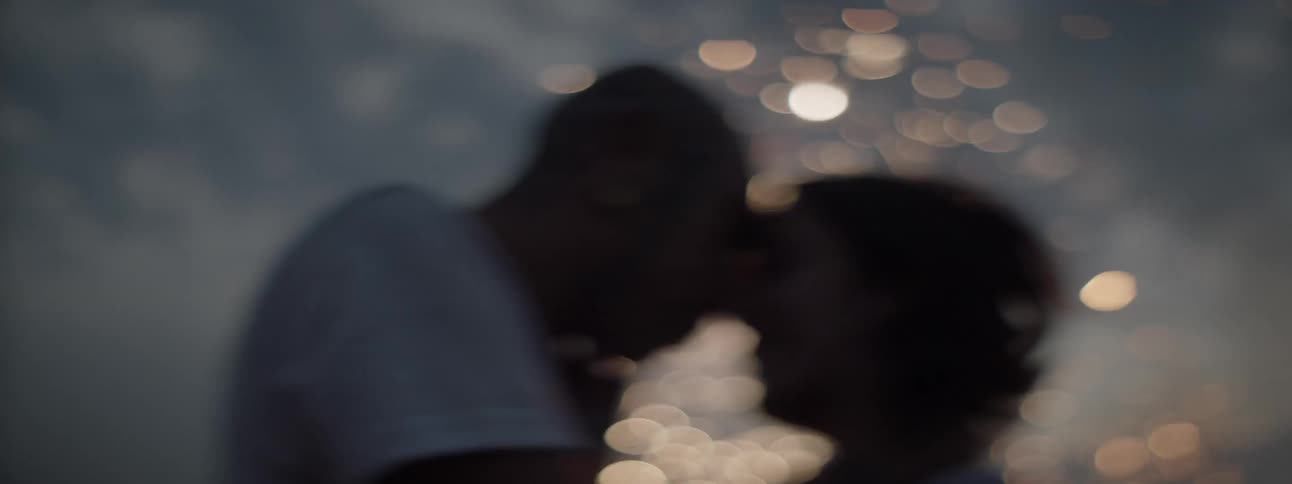 A man and woman put their faces together and embrace