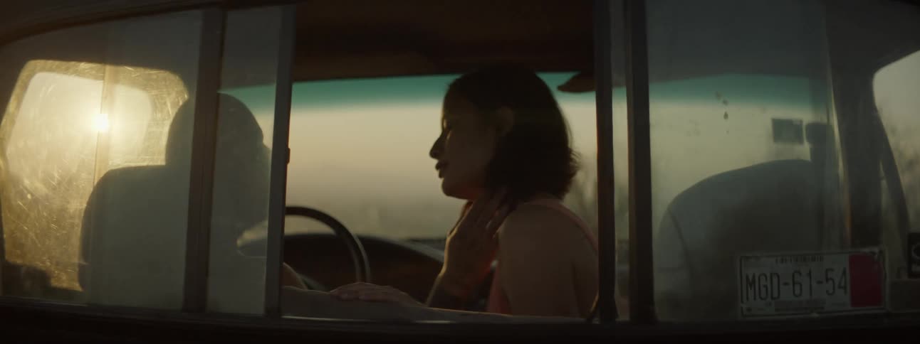 Man caresses a womans face then she lays her head on his shoulder as they sit in a vehicle