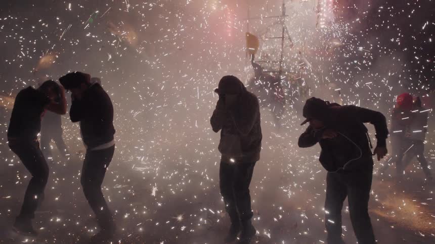 Crowd celebrates around bull model fireworks display