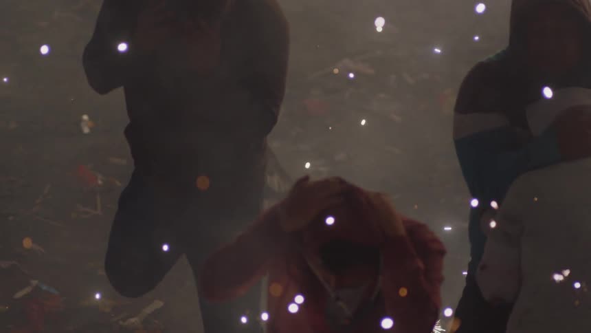 People celebrate outdoors among fireworks