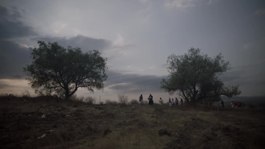 People walk up the hill together at sunset