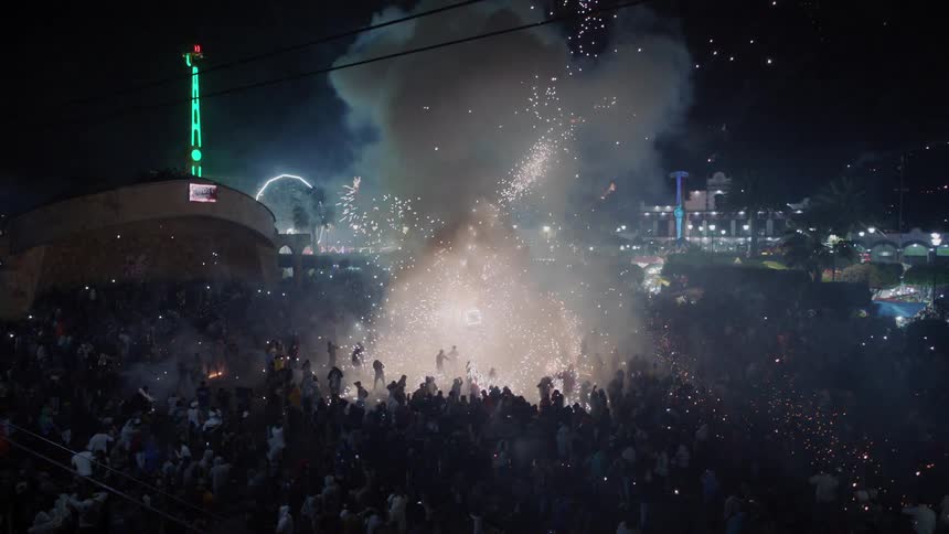 A large outdoor celebration with lights and fireworks