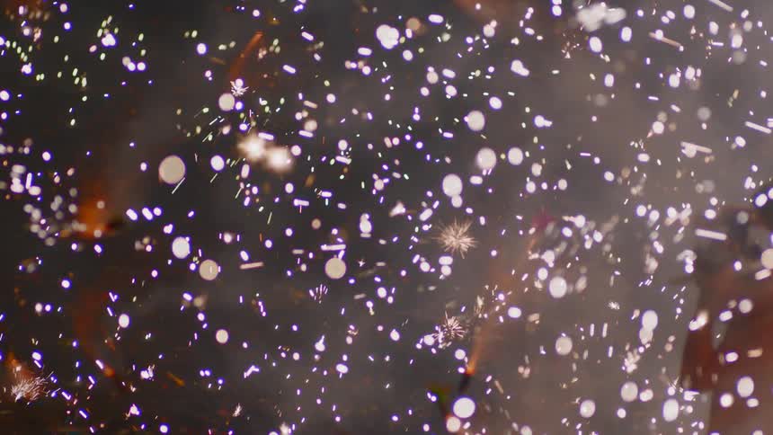 A few people turn for cover as countless sparks and small fireworks are going off everywhere around them