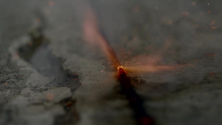 A flame sparks on the ash