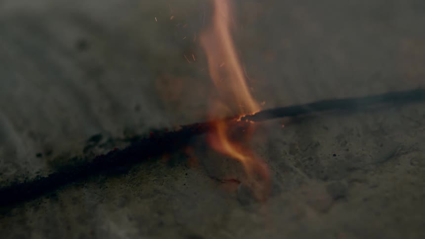 A lit fuse burning with fire and smoke