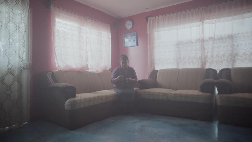 A woman sits on a sofa in a living room