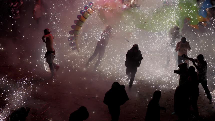 People jump and dance in the midst of sparks flying