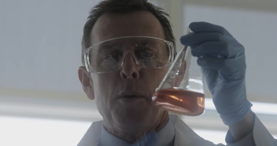 A man holds a beaker with liquid in it