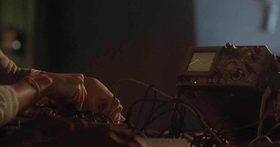 A girl turns dials as she looks at a monitor