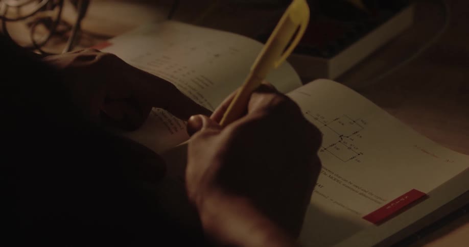 A person with a highlighter marking on a book