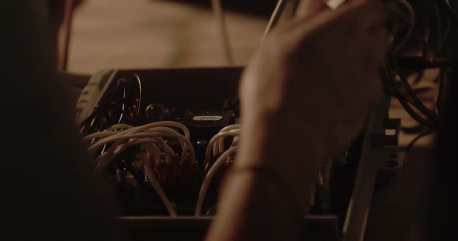 A person wires a circuit board on a table