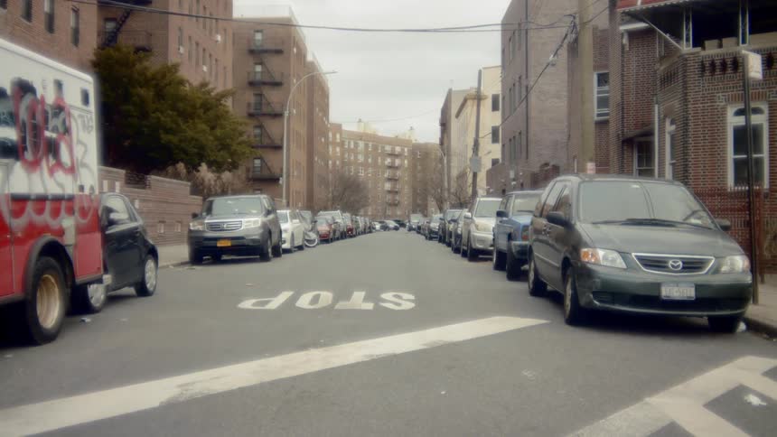 Parked cars line a residential street