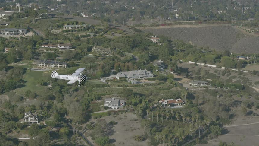 Aerial view of a small airplane flying over a small town