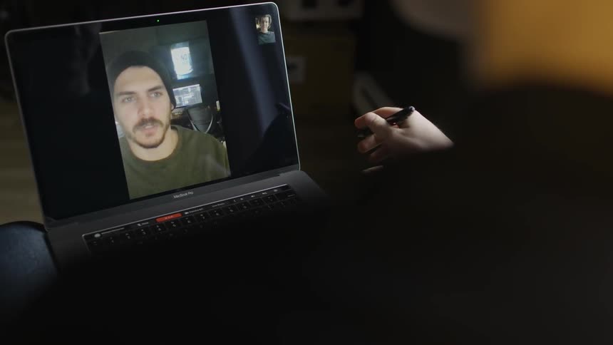 Person interacts via video call on laptop