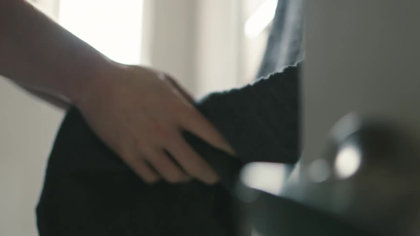 A person using a hanging towel to dry their hands
