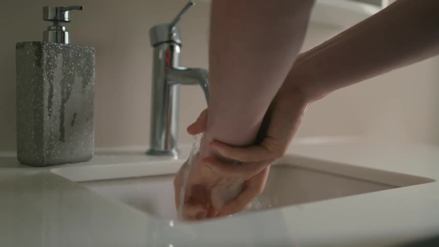 A person using a faucet to wash their hands