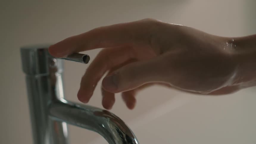 Person turns off faucet then rubs wet hands
