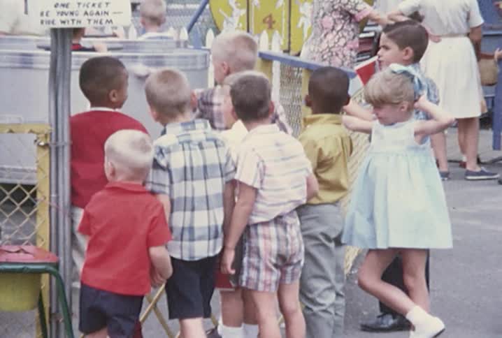Line of children waiting for a ride at a fair