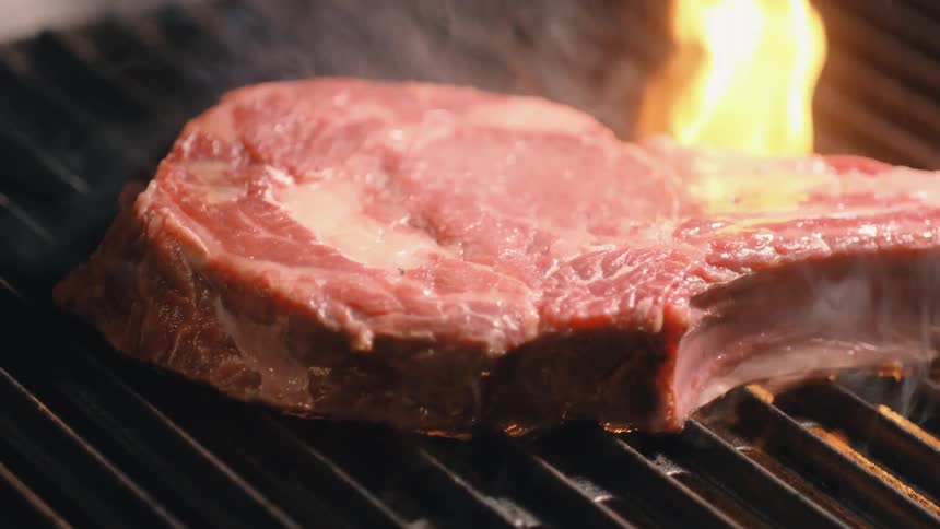 Cooking a piece of meat on a large grill