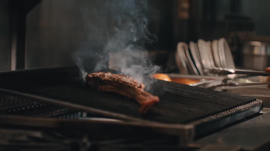 A steak is cooking on the grill