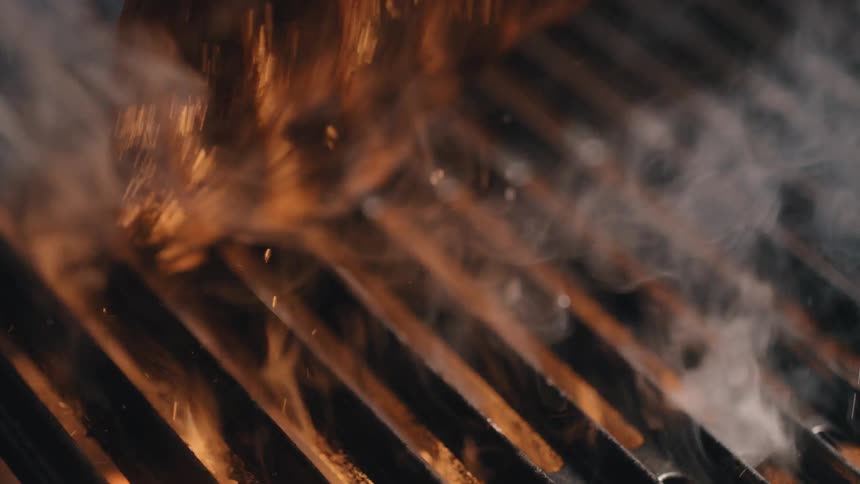 A ribeye steak is turned over on a grill