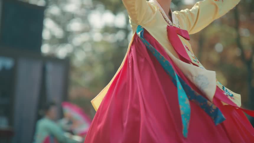 A woman dances in a large costume dress in front of a crowd
